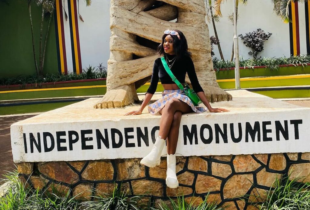 A woman standing at the iconic Independence Monument in Kampala, Uganda, gazing at the historic statue that symbolizes the nation's freedom. A must-see among statues and monuments in Kampala.