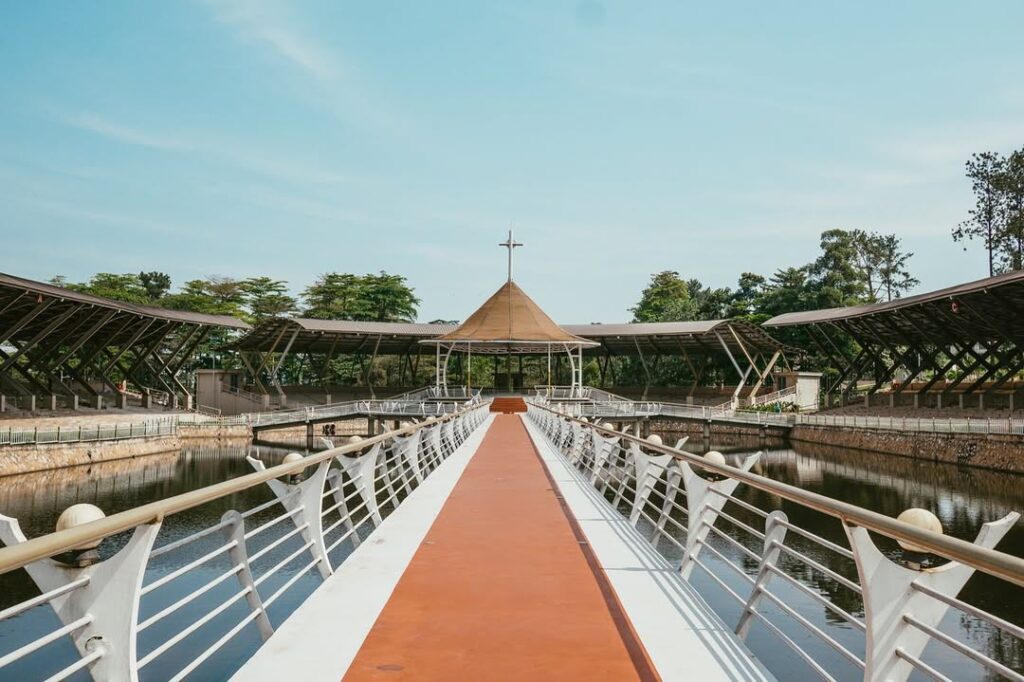 Martyrs’ Lake at Namugongo, a tranquil body of holy water surrounded by lush gardens, with a grass-thatched pavilion on the central island used for ceremonies.