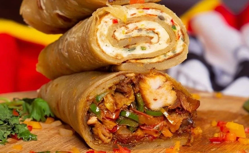 A delicious Ugandan Rolex wrapped in chapati, showcasing its golden, crispy exterior and fluffy omelet filling
