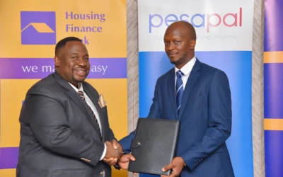 Ivan Kituuka, the Head of Distribution and alternate channels holding the partnership signed with Martin Barungi, the Managing Director of Pesapal Uganda