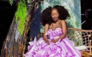 Anne Kansiime crying in a pink floral gown at the Comedy Grill event